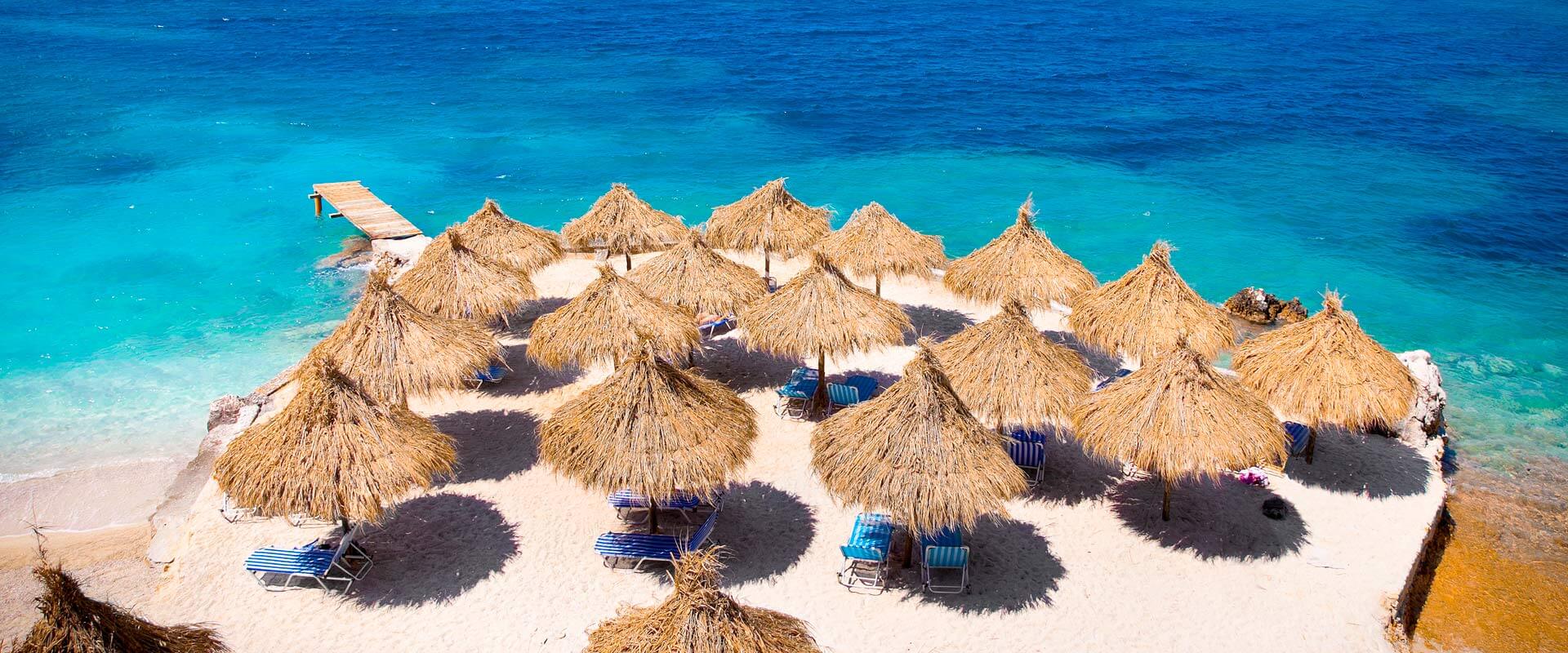 Sunshade umbrellas and deckchairs on the beautiful Ksamil beach, Albania.